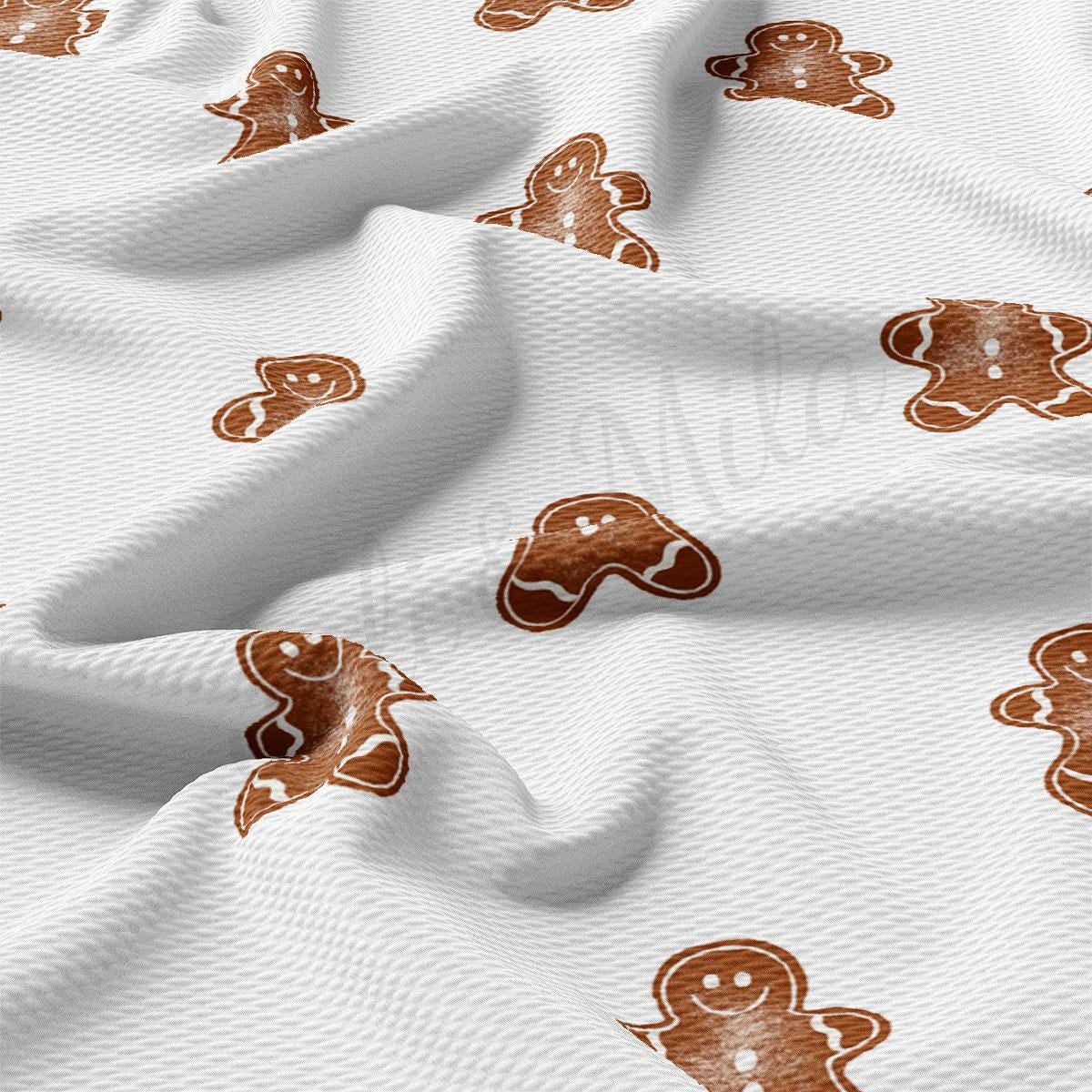 a close up of a white fabric with ginger cookies on it