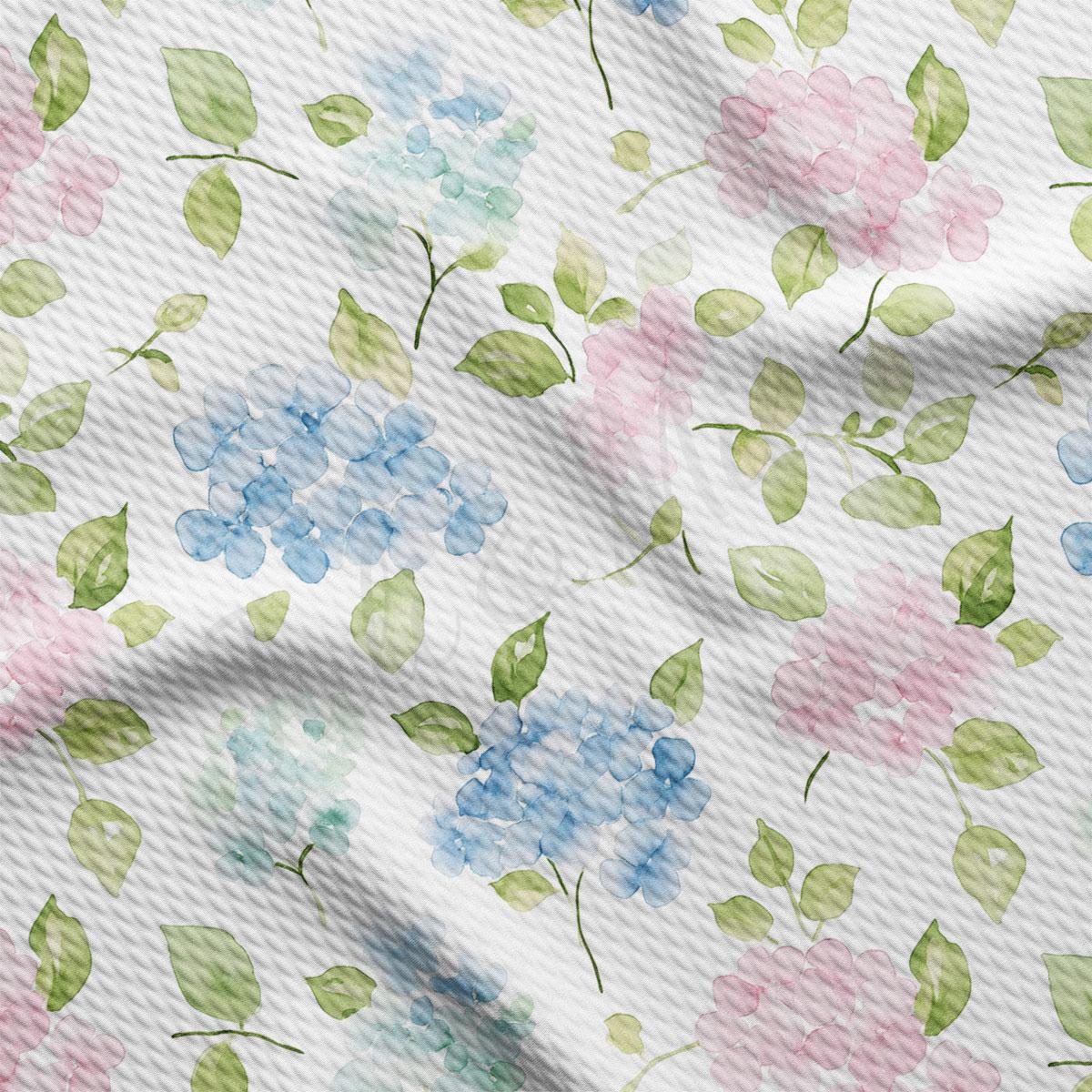 a close-up view of a fabric with a floral pattern. The pattern consists of various shades of blue, pink, and green flowers and leaves, creating a vibrant and colorful design. The fabric appears to be wrinkled, giving it a textured and natural appearance.