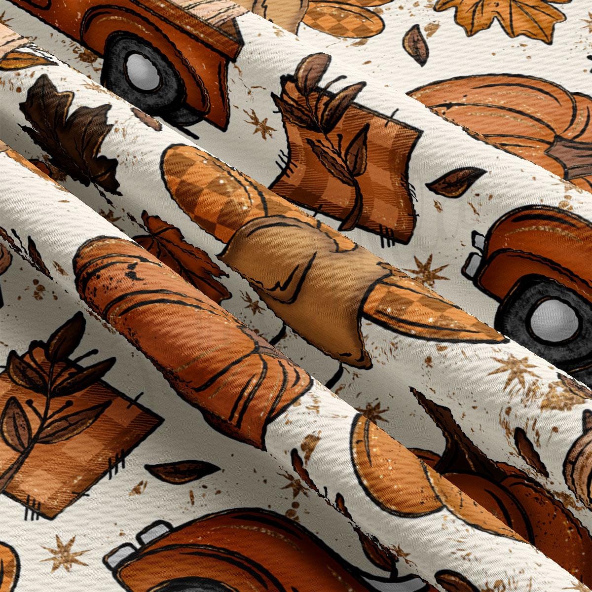 The image is a close-up of a fabric with a repeating pattern of autumn-themed elements, including leaves, pumpkins, and other fall-colored objects. The pattern is predominantly orange and brown, with some white and black accents. The fabric appears to be made of a soft, textured material, and the image is slightly tilted, giving it a dynamic and layered appearance.