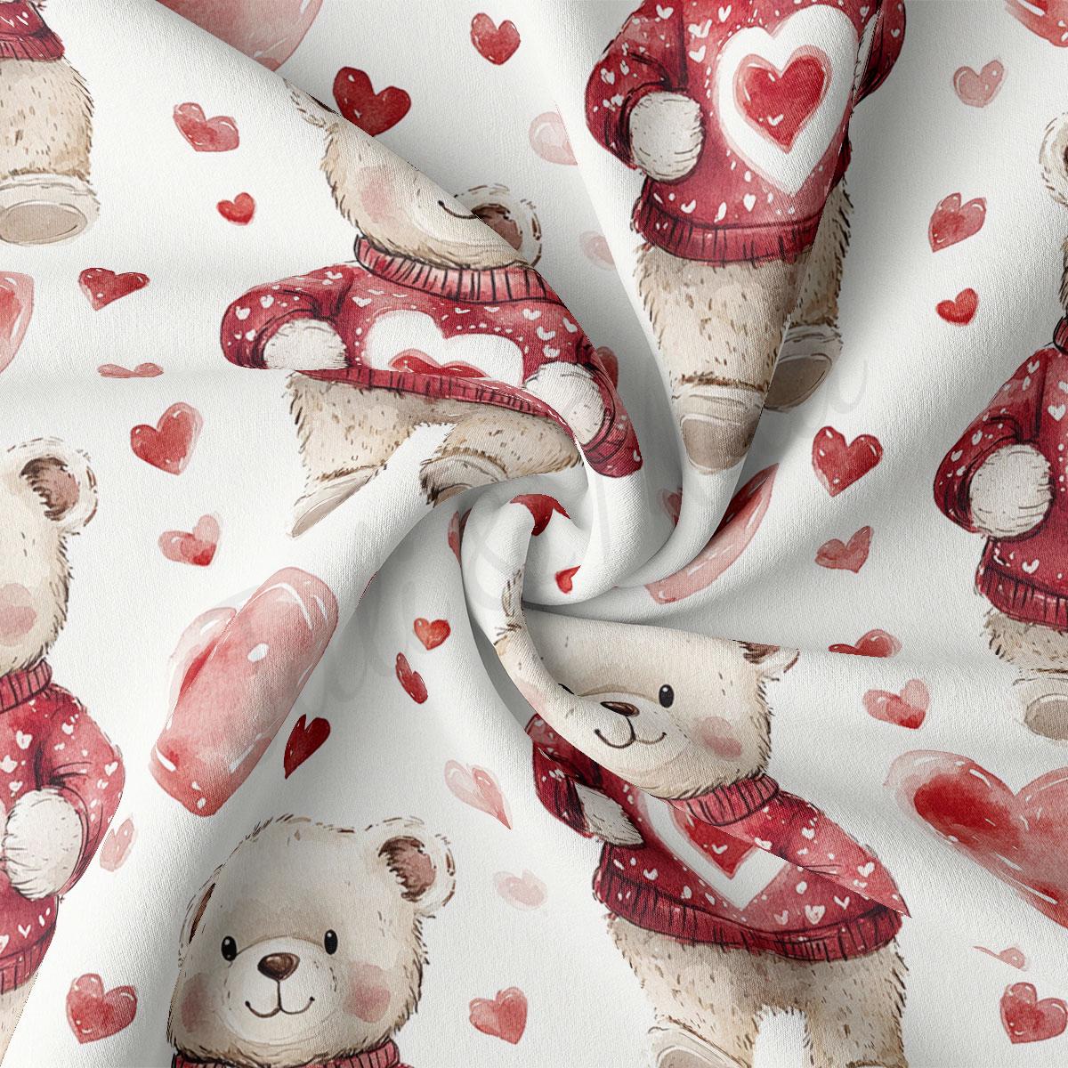 a close-up view of a fabric with a repeating pattern of teddy bears wearing red sweaters and holding hearts.