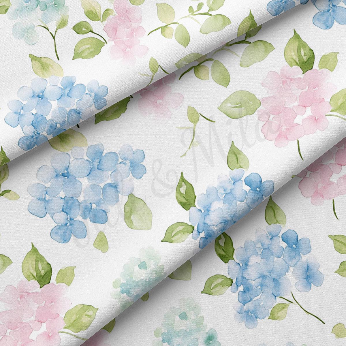 a close-up view of a fabric with a floral pattern. The pattern consists of various shades of blue and pink flowers, along with green leaves, creating a visually appealing and vibrant design.