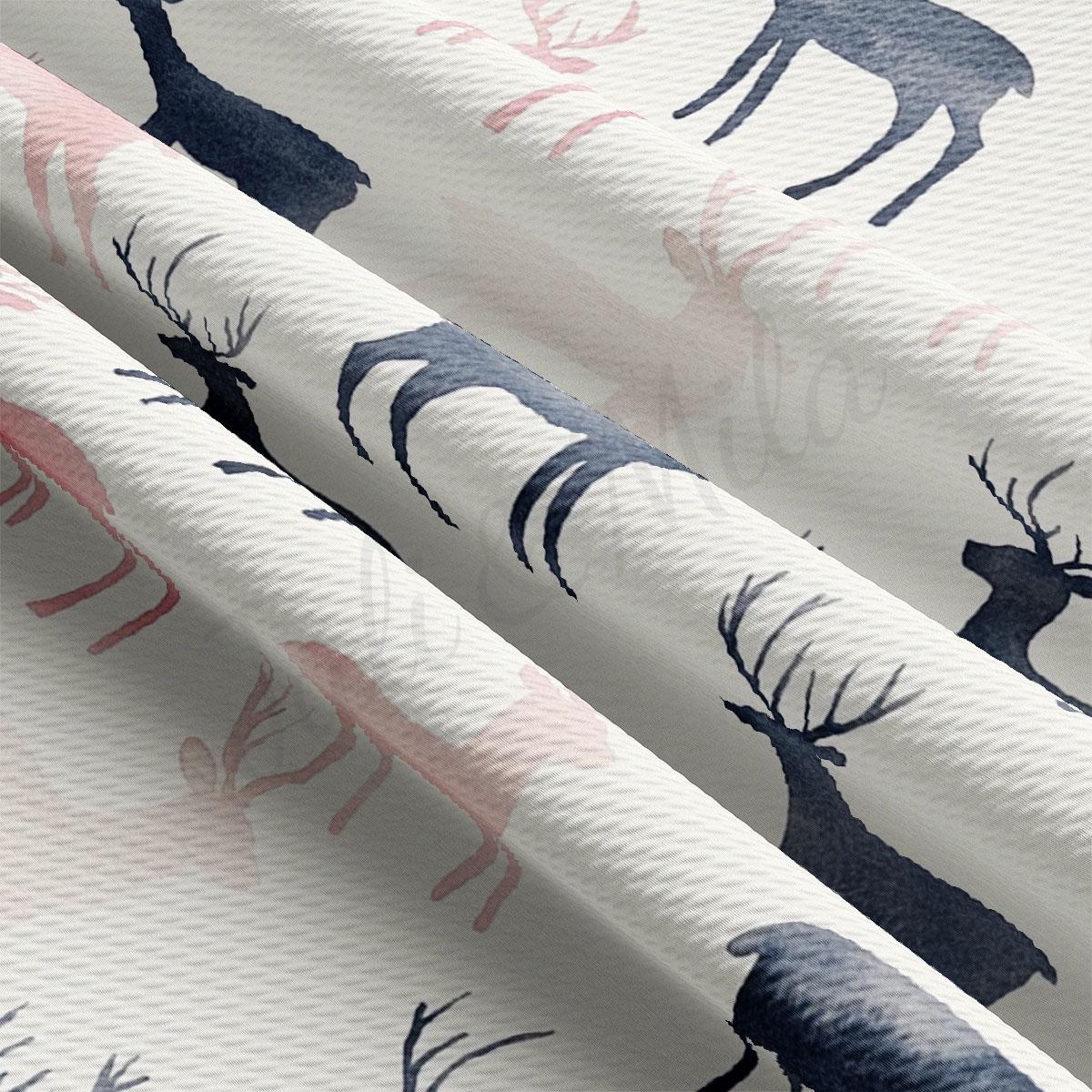 a close-up view of a fabric with a repeating pattern of deer silhouettes in shades of pink and blue.