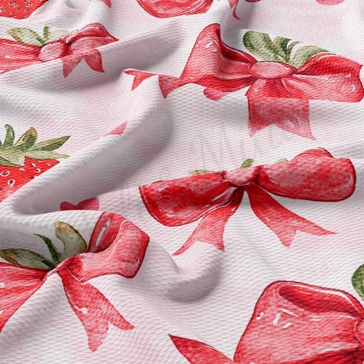 a close-up view of a fabric with a repeating pattern of red bows and strawberries.