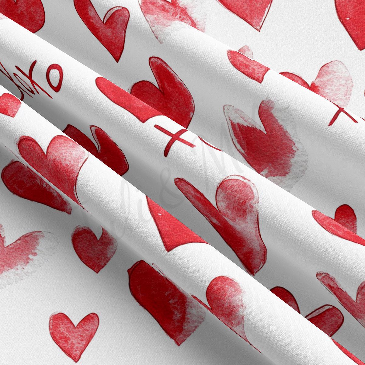 a close-up view of a fabric with a repeating pattern of red hearts on a white background.