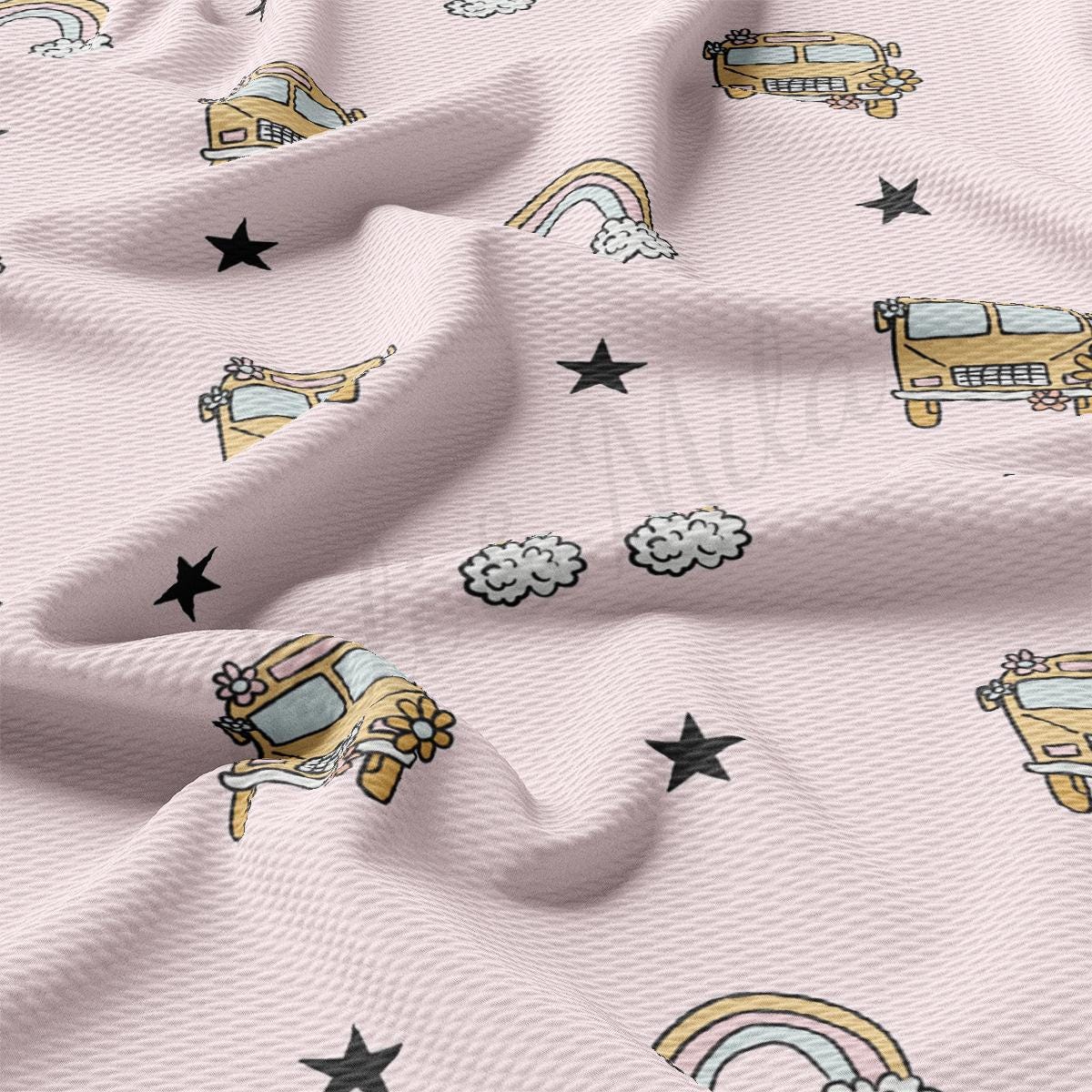 a pink fabric with a pattern of school buses and stars
