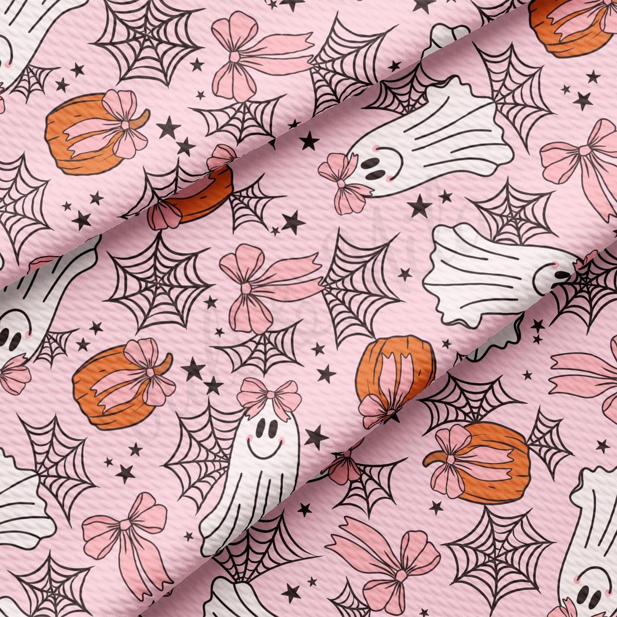 a pink background with a pattern of ghost and spider webs