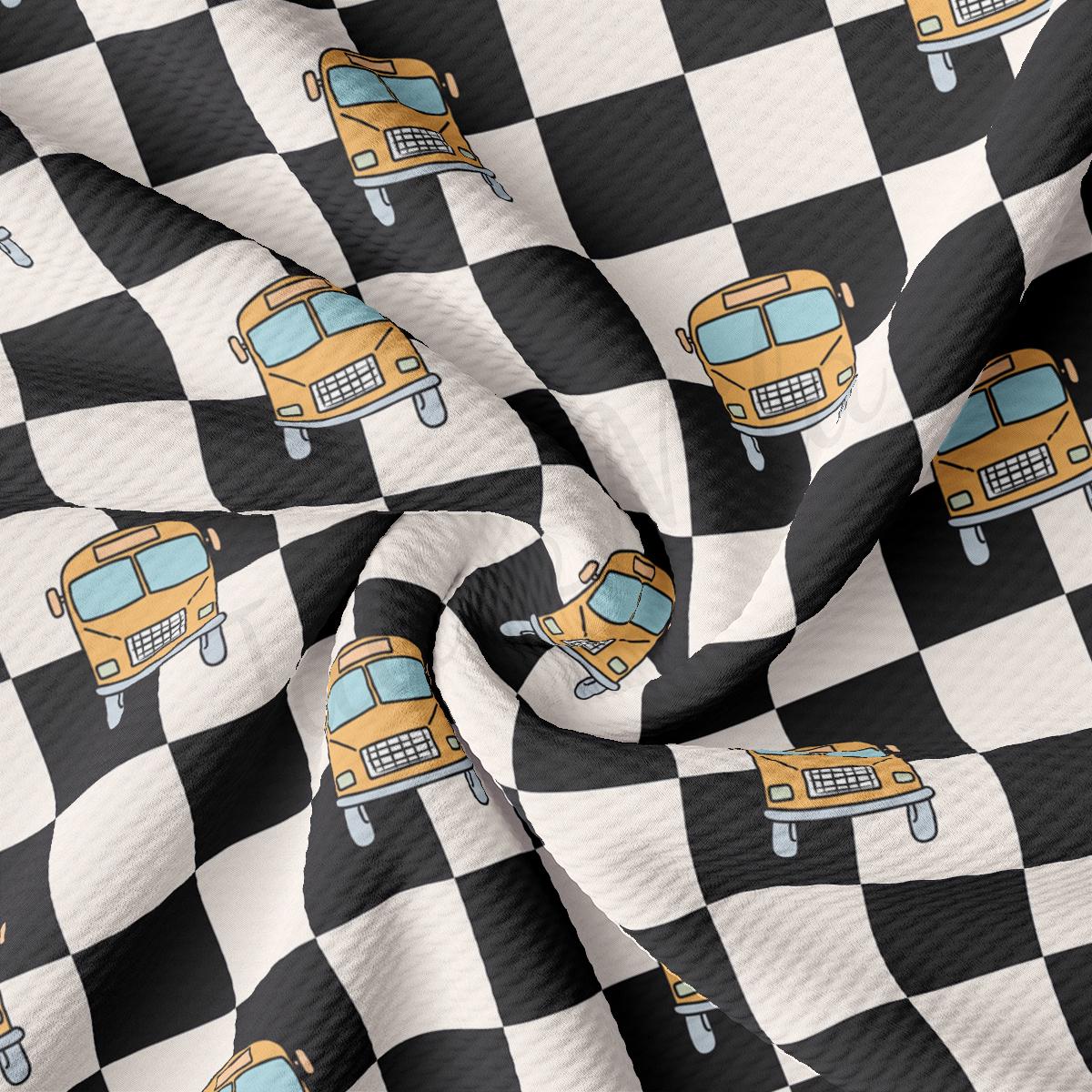 a black and white checkered fabric with a yellow school bus on it
