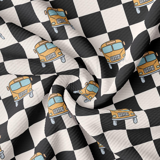 a black and white checkered fabric with a yellow school bus on it