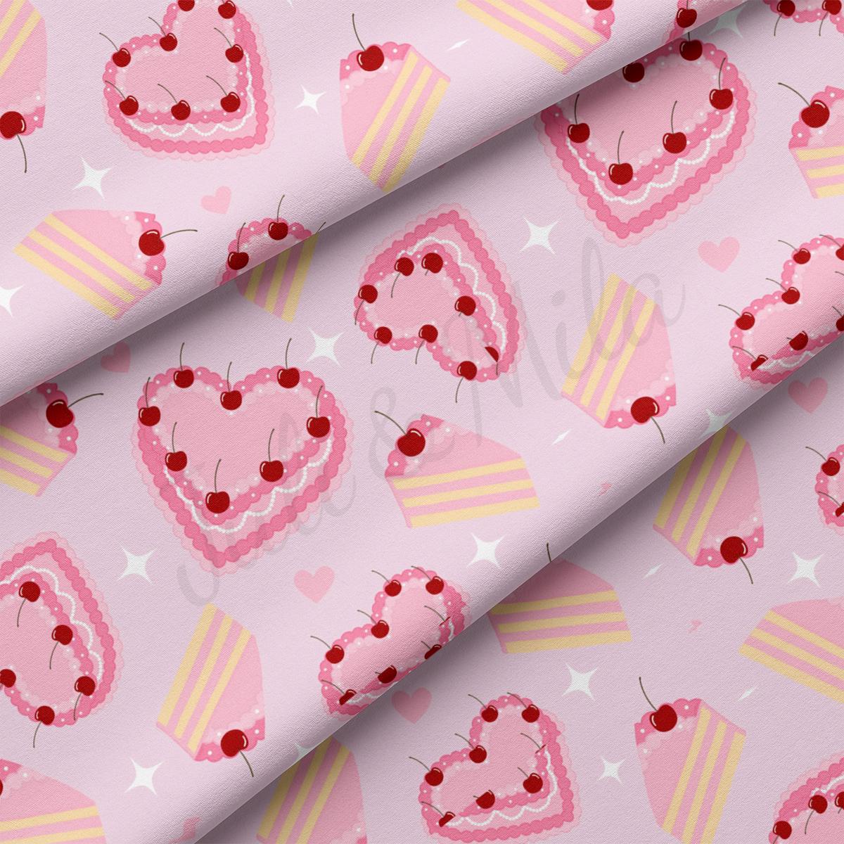 a pink fabric with hearts and cherries on it