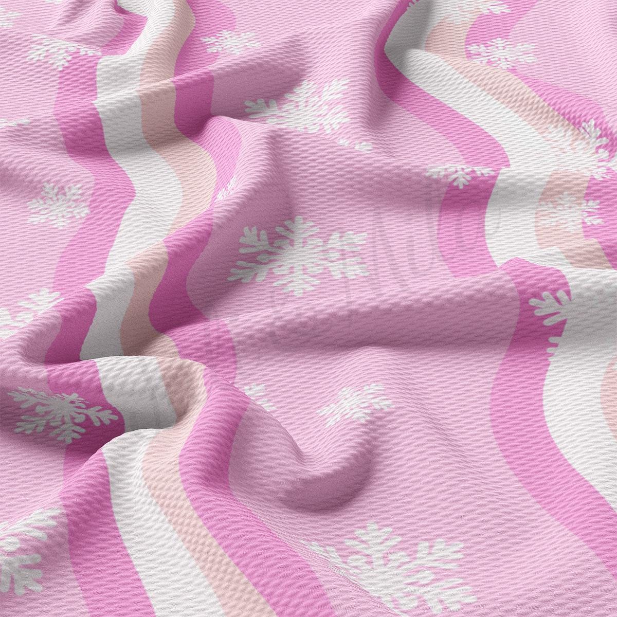 a pink and white blanket with snowflakes on it